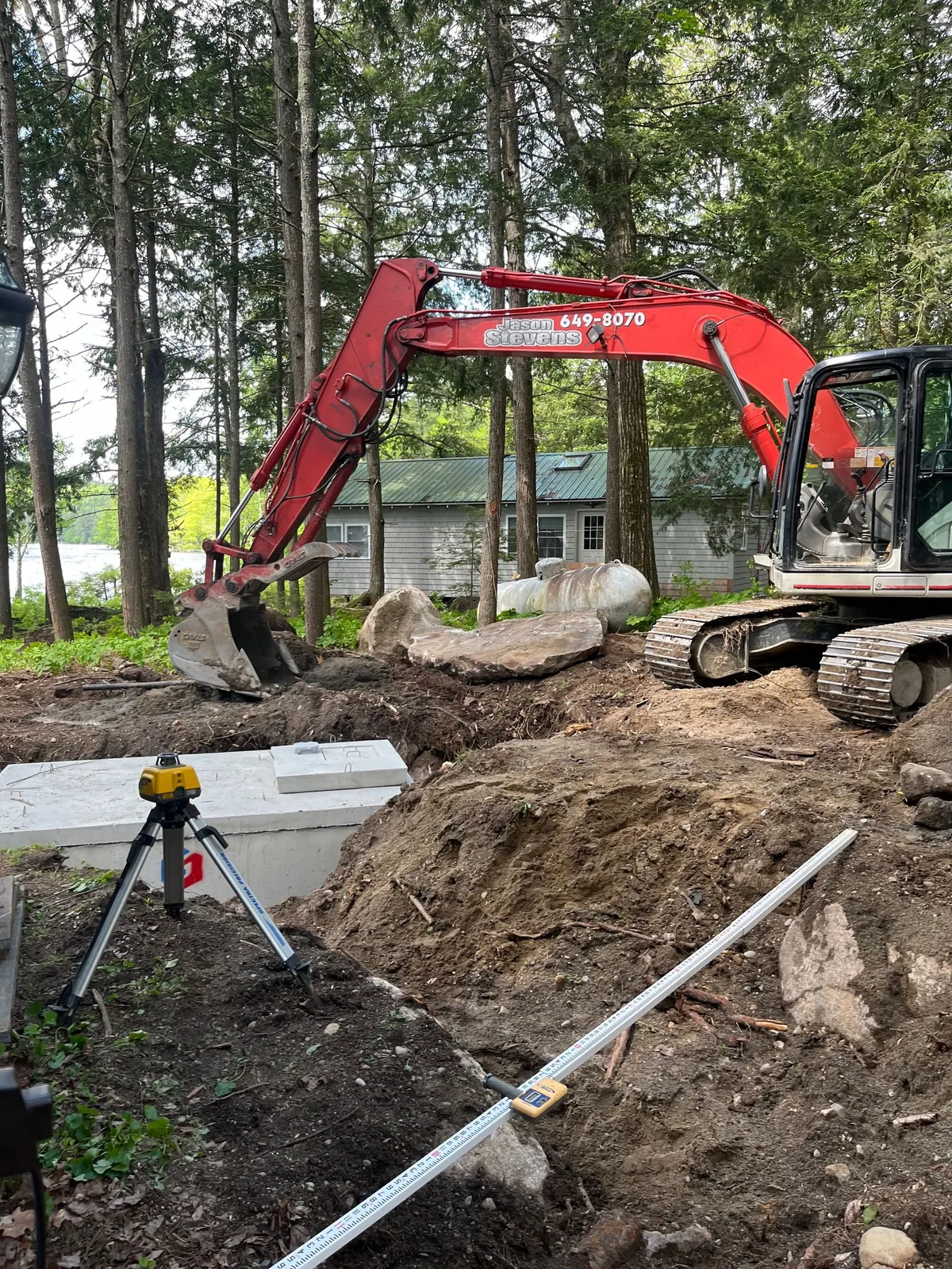 Excavator digging on a residential lot.
