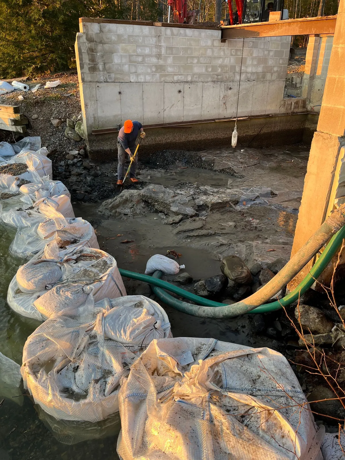 Excavator working near a residential structure.